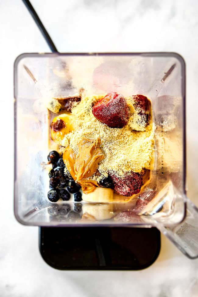 showing how to make acai bowls by adding peanut butter, protein powder,bananas, strawberries, blueberries and milk to blender
