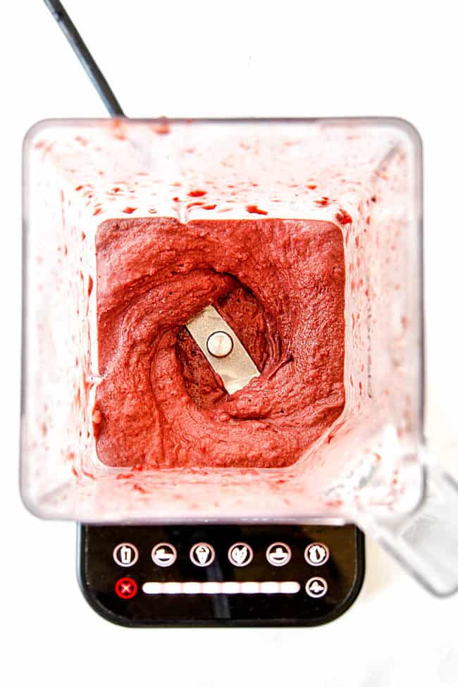 showing how to make acai bowl by blending it in a blender until smooth