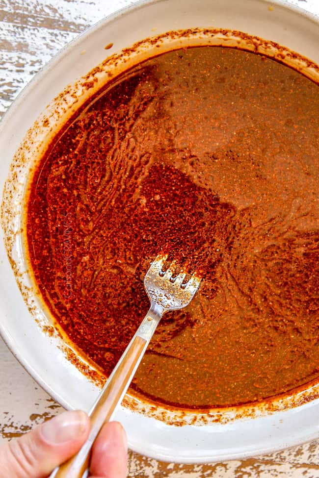 showing how to make carne asada tacos by whisking marinade ingredients together