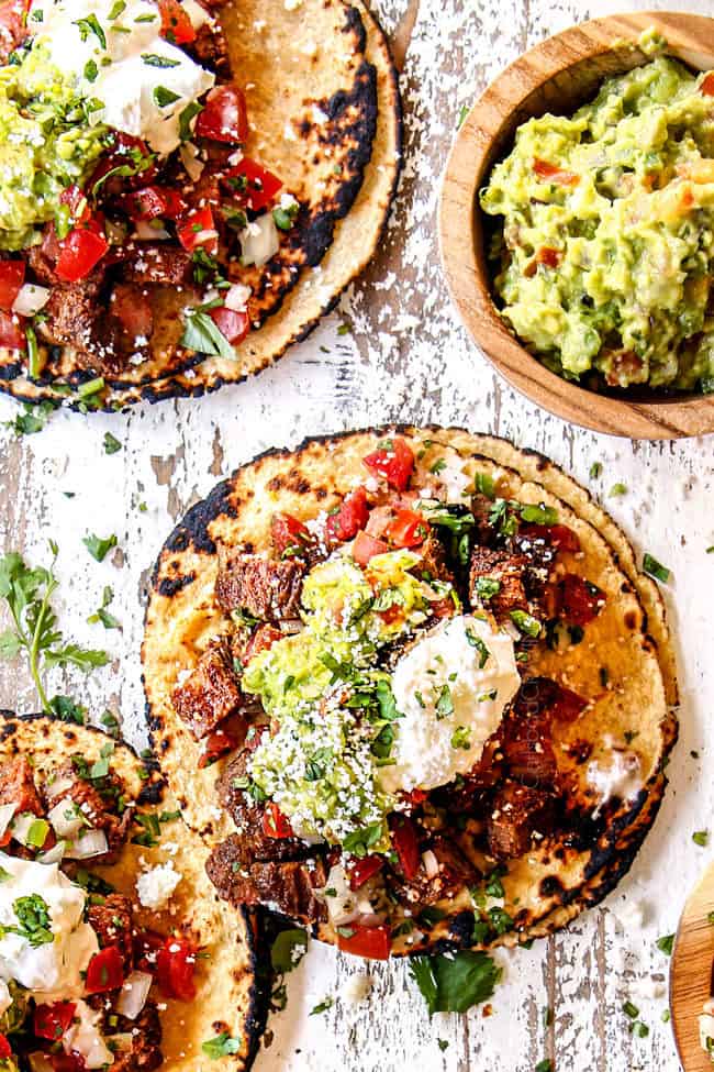 top view of carne asada tacos with carne asada, guacamole, sour cream, pico de gallo