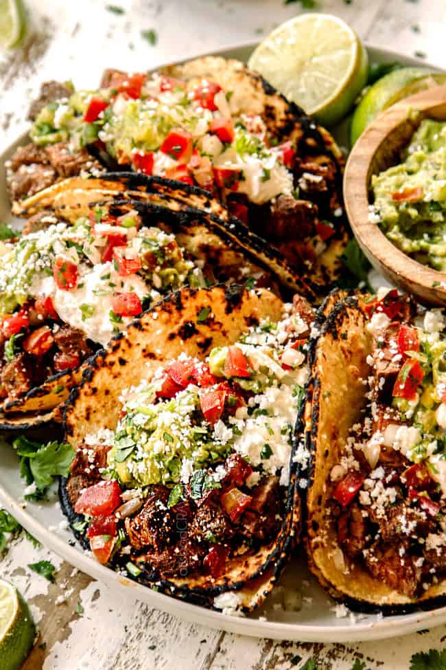 authentic Mexican street tacos lined up on a plate with