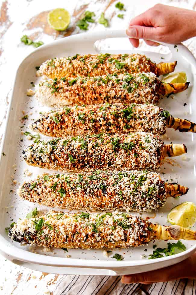 serving Mexican elote lined up on a white platter