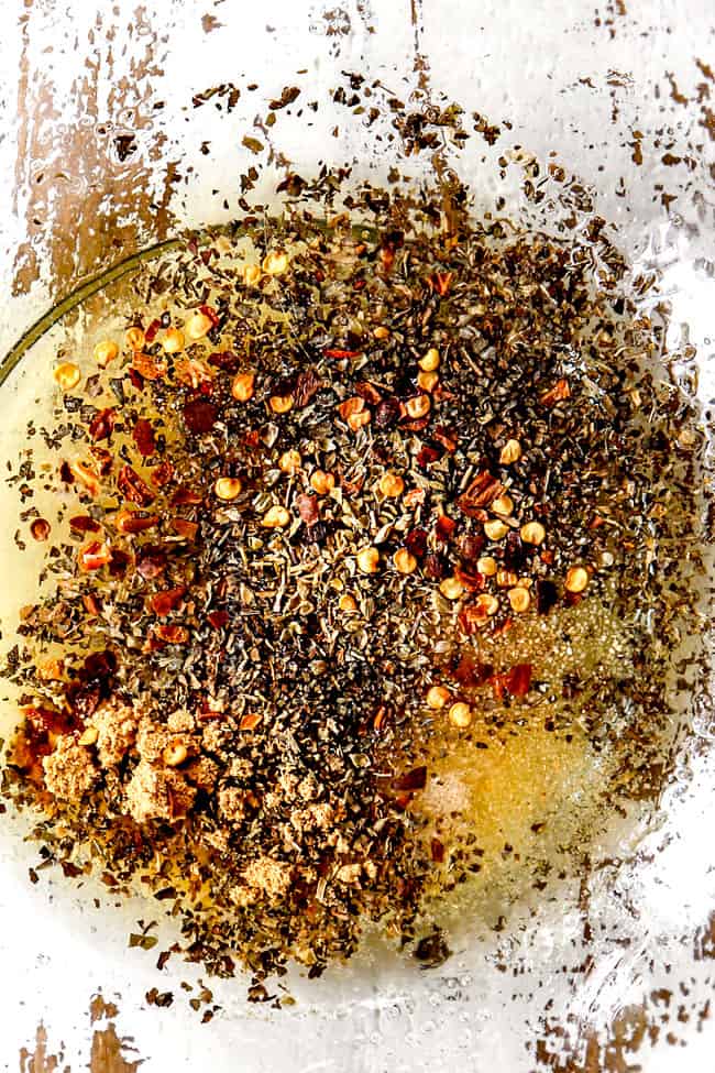 showing how to make lemon chicken pasta by adding chicken marinade ingredients: olive oil, lemon juice, red pepper, oregano, basil, to a bowl