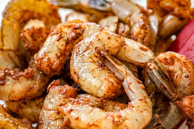 showing how to make stuffed zucchini boats by tossing shrimp filling with spices