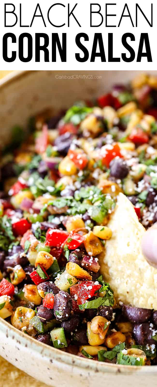 up close of scooping a chip in black bean and corn salsa recipe