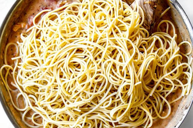 showing how to make easy chicken spaghetti by adding spaghetti pasta to sauce
