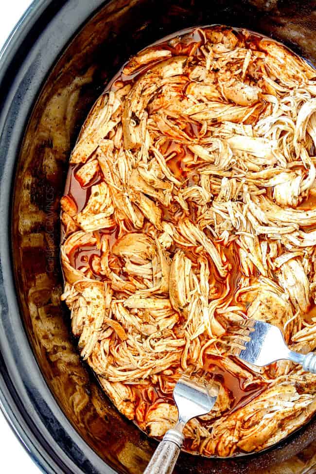 crockpot buffalo chicken by shredding chicken in slow cooker