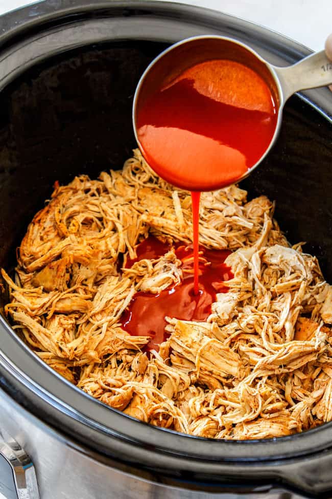 crockpot buffalo chicken by adding buffalo sauce to shredded chicken