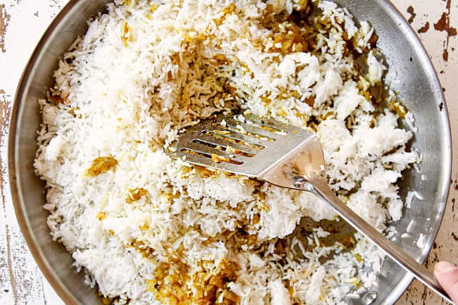 showing how to make pineapple fried rice by pushing rice down in skillet to fry