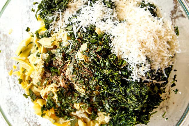 showing how to make ricotta filling for white lasagna by adding ricotta, sour cream, spinach, artichokes and Parmesan to a large glass bowl