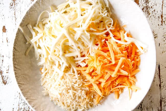 showing how to make cheesy garlic bread recipe by mixing mozzarella, Parmesan and cheddar cheese together in a white bowl