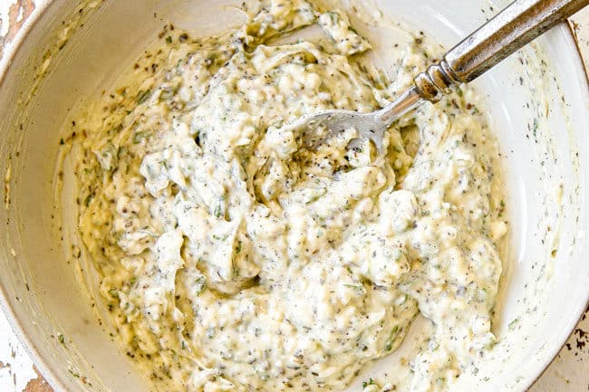 showing how to make garlic butter spread for Garlic Bread by mixing butter, garlic and herbs in a bowl until combined