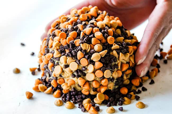 showing how to make peanut butter balls by pressing coating into the peanut butter ball