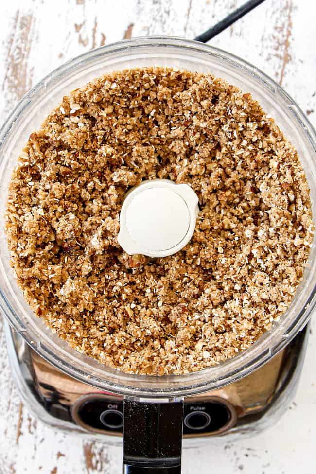 showing how to make best pumpkin cheesecake bars by making chopping butter, flour, oats, pecans and sugar for streusel in