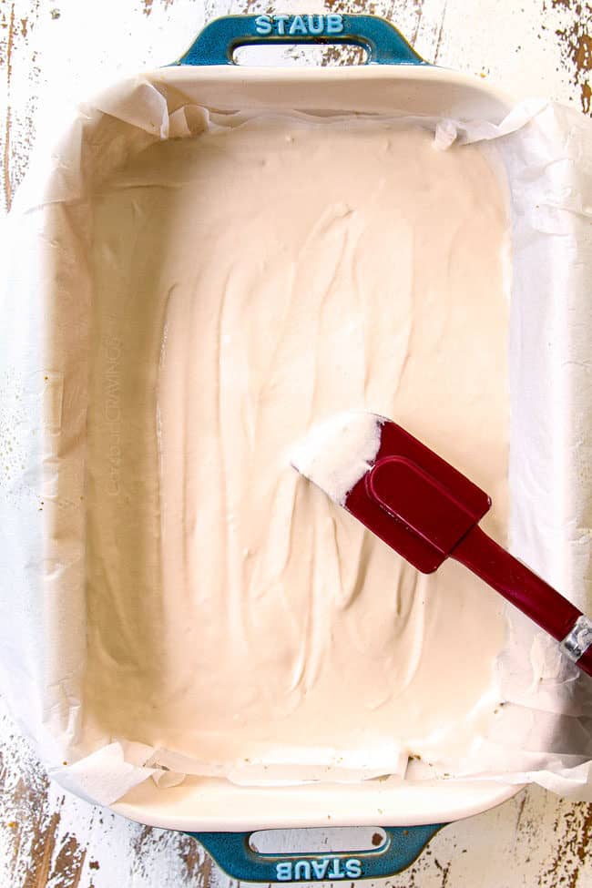 showing how to make pumpkin cheesecake bars by spreading cheesecake on top of crust