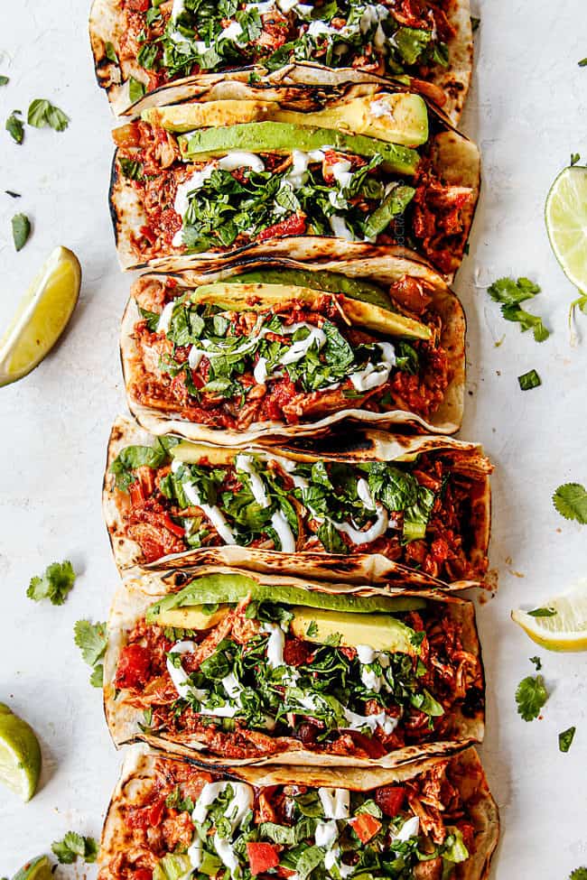 showing how to make shredded chicken tacos by making a topping bar