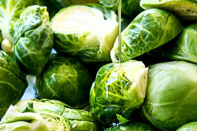 showing how to cook Brussels Sprouts recipe by drizzling with olive oil on a baking sheet