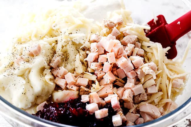 showing how to make leftover turkey recipe by adding chopped turkey, mashed potatoes, and cranberry sauce to a glass bowl