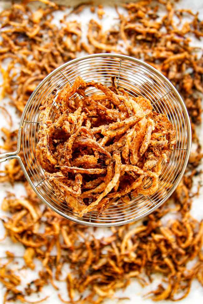 showing how to make burger recipe by frying onion strings until golden