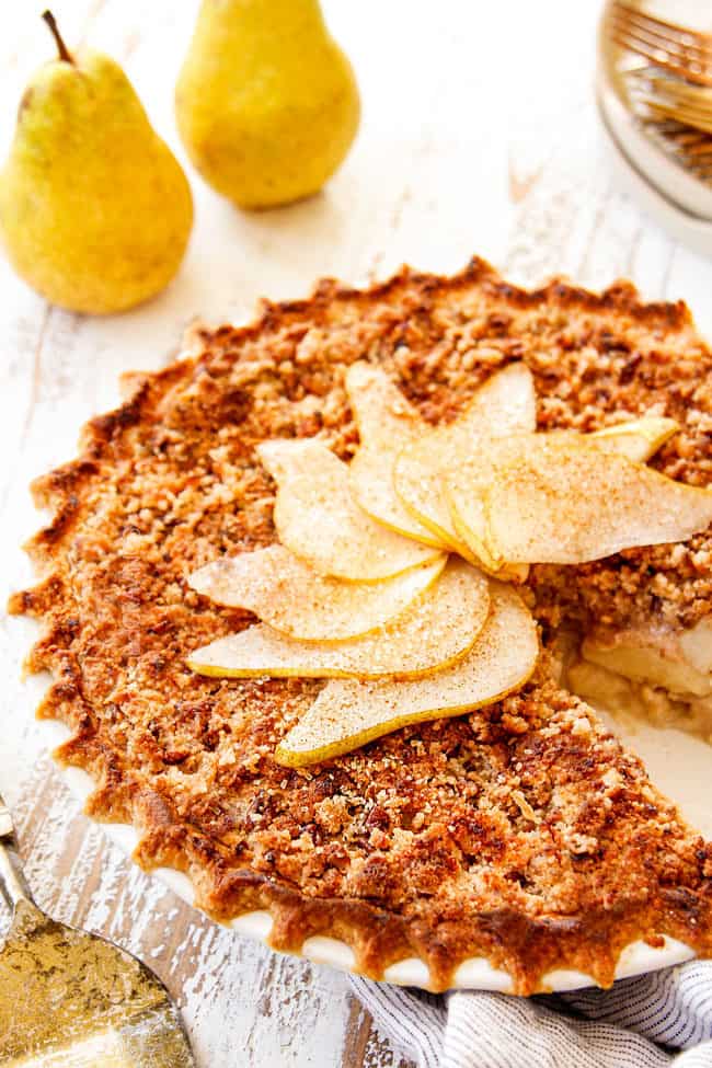 showing how to garnish old fashioned pear pie recipe by adding sliced pears on top of streusel topping