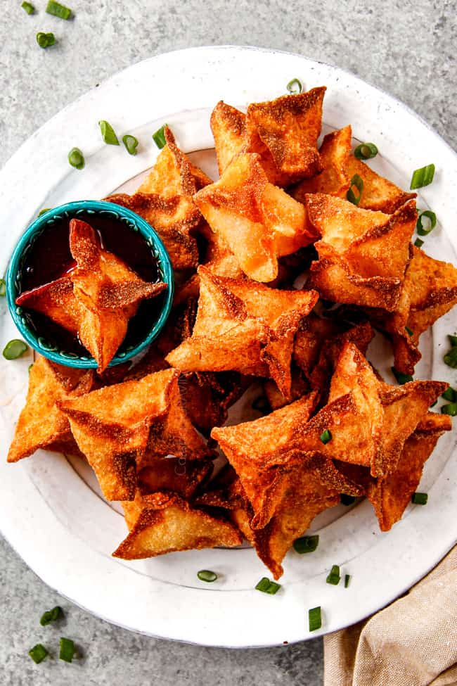 top view of crab rangoon recipe on a platter with sweet and sour sauce