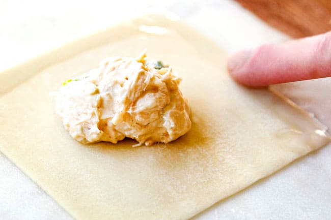 showing how to make homemade crab rangoon brushing edges with waterby