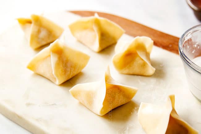 showing how to make crab rangoon by folding into pouches