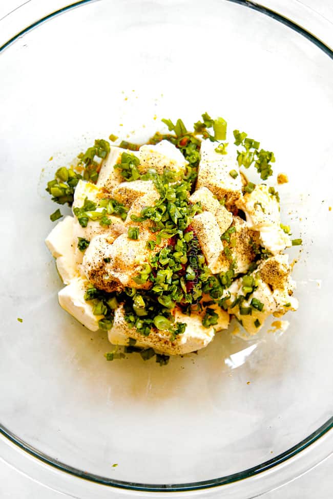 showing how to make crab rangoon by adding cream cheese, green onions, garlic, Worcestershire sauce to a large mixing bowl