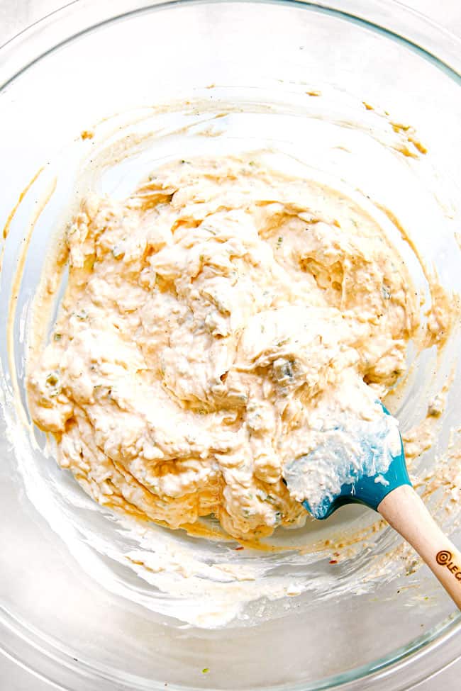 showing how to make crab rangoon by mixing cream cheese and green onions until smooth