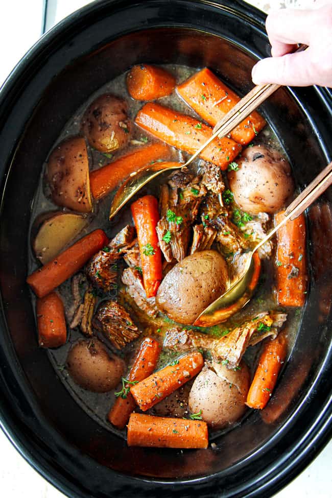 showing how to cook a roast in a crock pot by shredding chuck roast in the crockpot