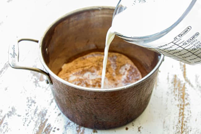 showing how to make homemade hot chocolate recipe by adding milk and heavy cream