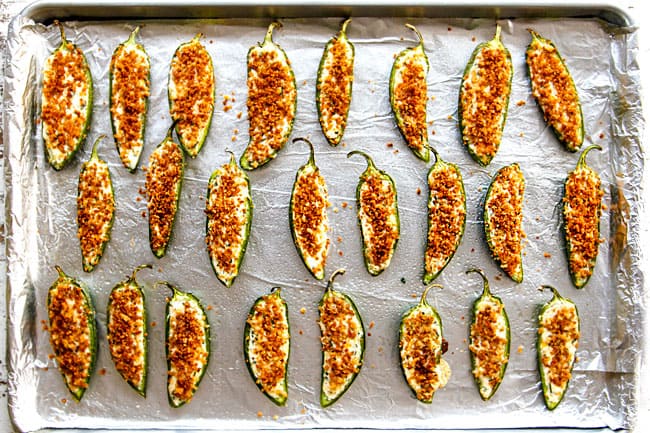 showing how to make jalapeno poppers by lining jalapeno poppers on a baking sheet to bake
