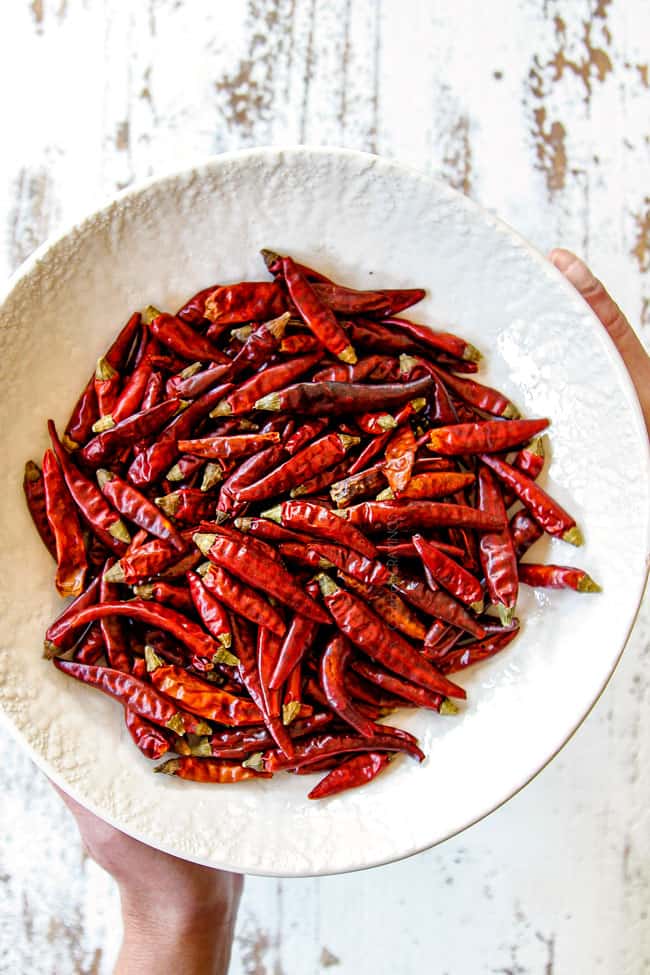 showing what chilies to use in kung pao chicken recipe by holding a bowl of red chilies