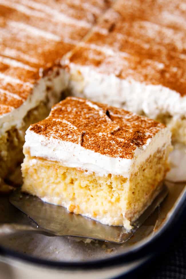 up close of serving a piece of easy tres leches cake recipe from a 9x13 pan