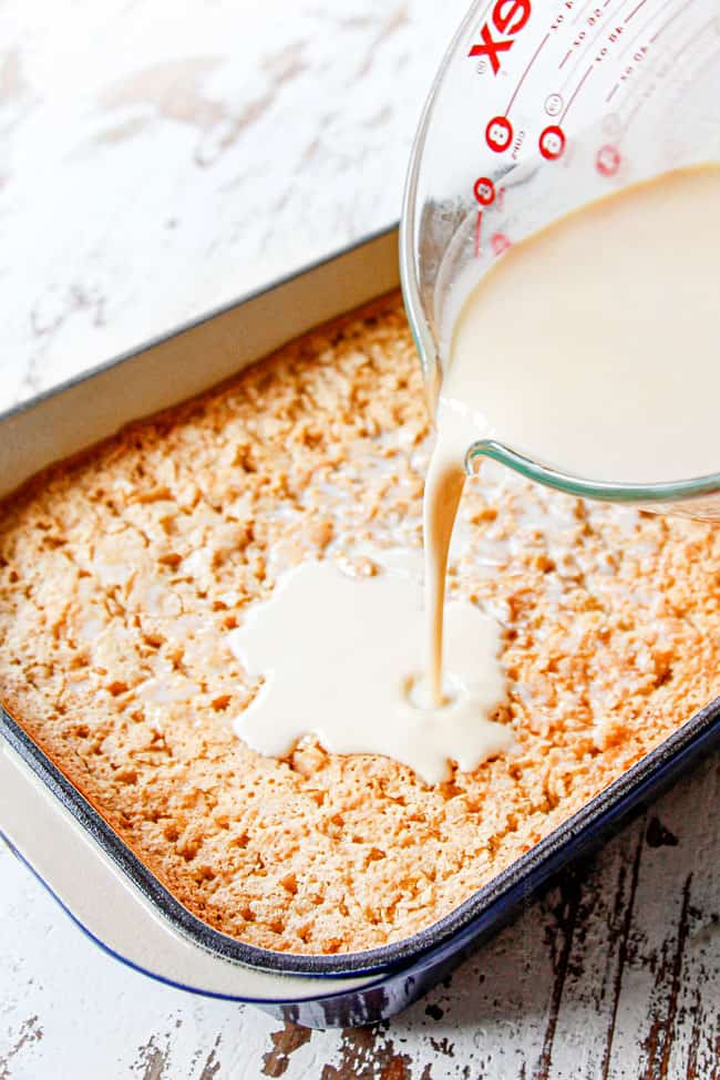 showing how to make tres leches cake recipe by pouring tres leches over cake