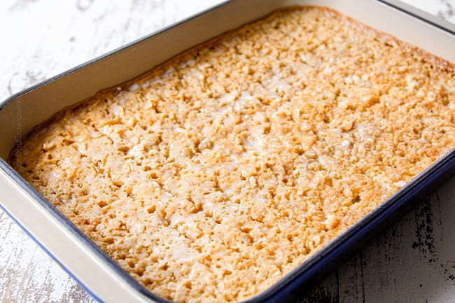 showing how to make authentic tres leches cake by letting the tres leches sink into cake