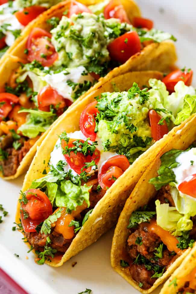 up close of showing what toppings for beef taco recipe by adding lettuce to tacos