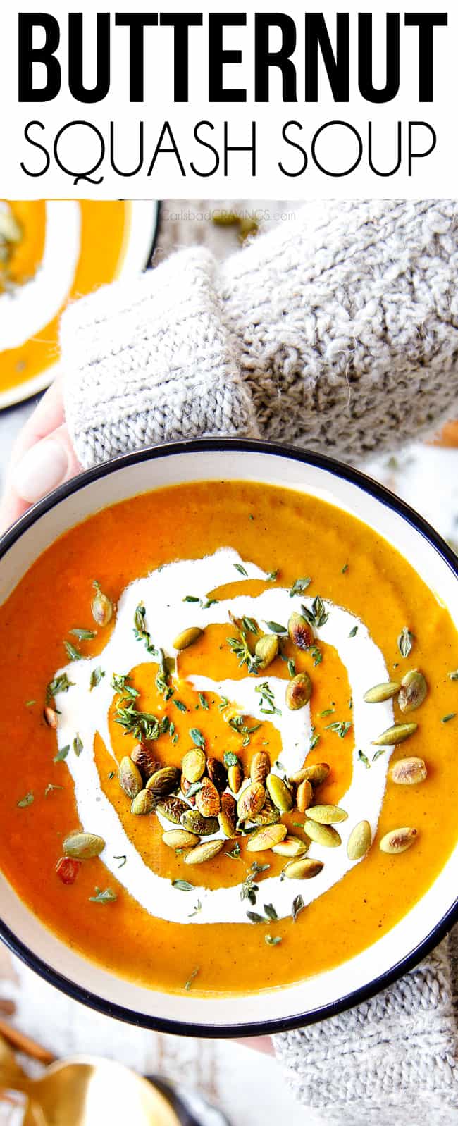top view of two hands holding a bowl of the best butternut squash soup recipe