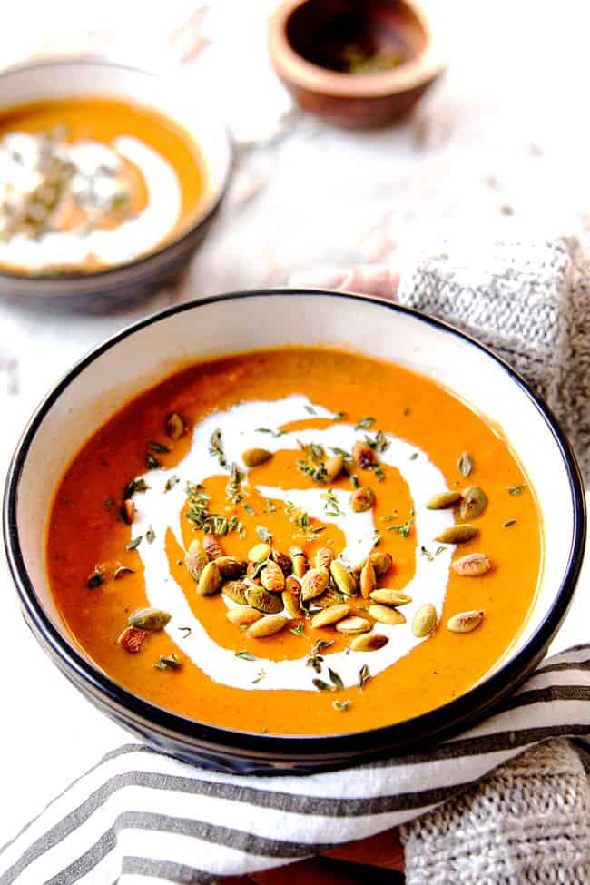 two hand holding a bowl of creamy butternut squash soup recipe