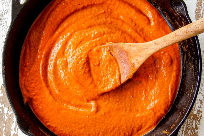 showing how to make chicken tinga by adding smooth sauce from blender to skillet