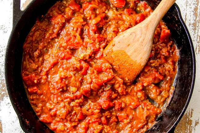 showing how to make chicken tinga by cooking onions, garlic, chipotle pepper together in a skillet