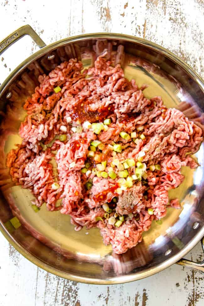 showing how to make Egg Roll in a Bowl by adding pork, green onions and chili sauce to skillet