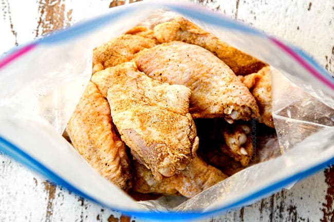 showing how to make Korean Chicken Wings by adding chicken wings to a freezer bag and tossing with spice rub