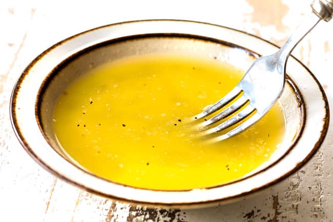 showing how to make lemon pepper wings recipe by whisking lemon pepper wing sauce ingredients together