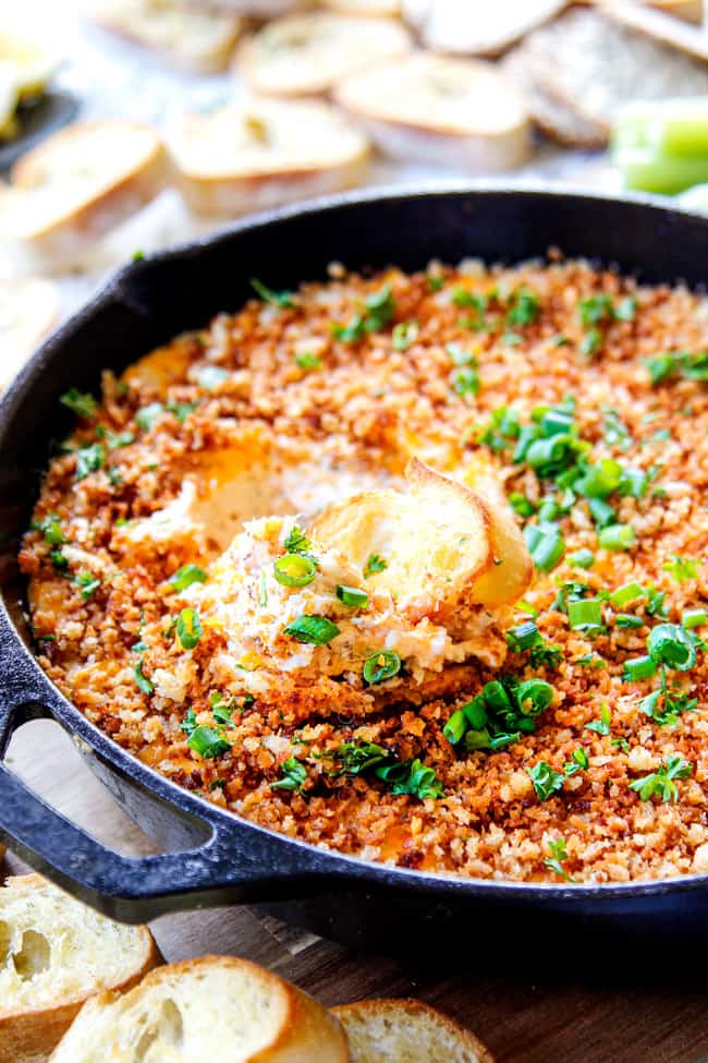 a skillet of baked crab dip coming out of the oven