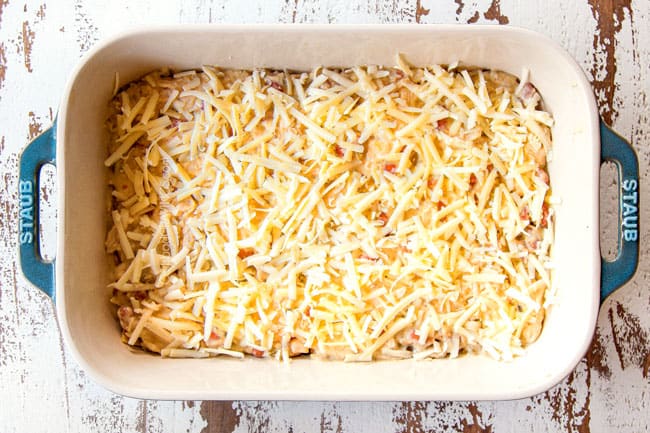 showing how to make layered chicken enchilada casserole recipe by layering chicken with cheese