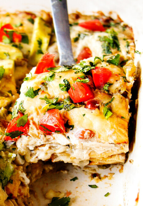 up close of serving chicken enchilada casserole recipe with a slice on a silver spatula