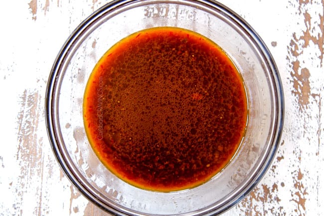 showing how to make Moo Goo Gai Pan sauce by whisking chicken broth, soy sauce, oyster sauce, rice wine and toasted sesame oil together