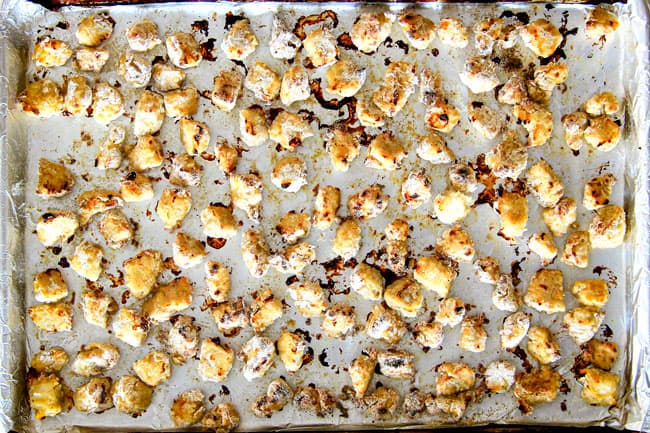 showing how to make baked orange chicken by spreading chicken onto a baking sheet