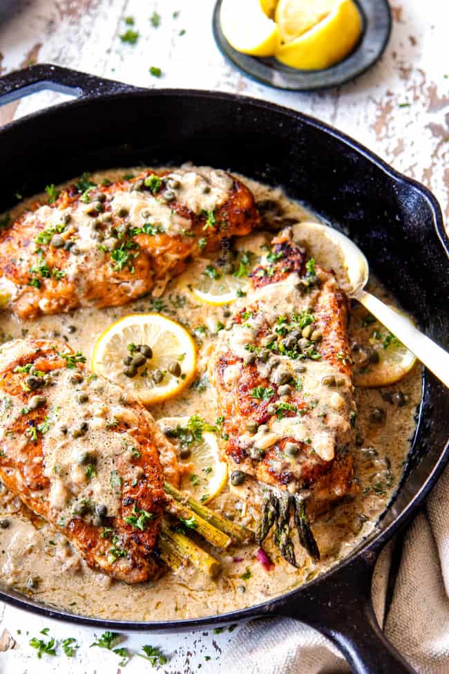 showing how to serve Chicken Piccata by spooning sauce over the chicken
